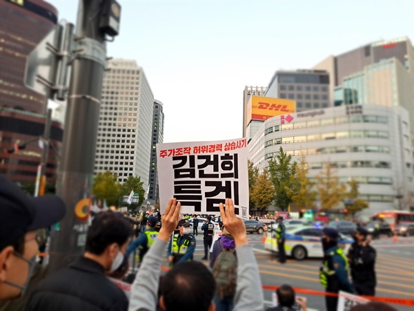 22일 오후 촛불행동 주최 제11차 촛불대행진이 진행된 서울시청 인근에서 시민들이 피켓을 들고 있다.