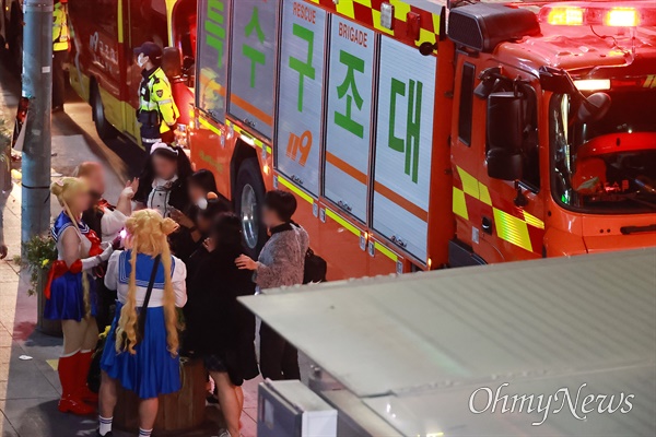 핼러윈 축제가 열리던 서울 용산구 이태원에서 10월 29일 밤 10시22분경 대규모 압사사고가 발생해 1백여명이 사망하고 다수가 부상을 당하는 참사가 발생했다. 참사 현장에서 부상자와 사망자 이송이 이뤄지고 있는 가운데 핼러윈 복장을 한 사람들이 모여 이야기를 나누고 있다.