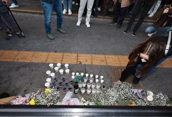 30일 오후 서울 용산구 지하철 6호선 이태원역 1번 출구 앞에 마련된 '핼러윈 인파' 압사 사고 희생자 추모 공간에서 한 외국인이 헌화하고 있다.