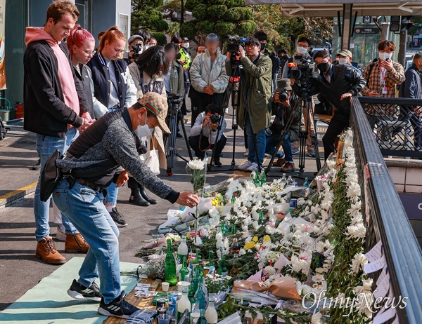 31일 오후 서울 용산구 이태원역 1번 출구앞에 마련된 이태원 압사 참사 희생자 추모공간에서 내외국인들이 희생자들을 추모하고 있다.