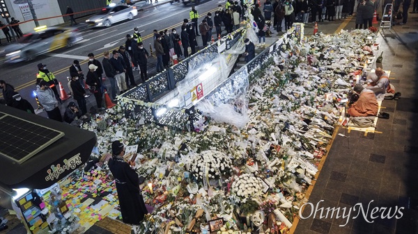 지난 3일 밤 서울 용산구 이태원역 1번 출구에 마련된 이태원 압사참사 희생자 추모공간에서 내외국인들이 찾아와 희생자들을 추모하고 있다.