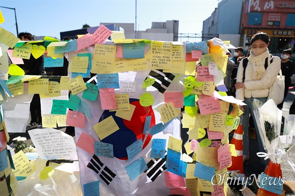 지난 5일 오후 이태원 압사 참사 추모공간이 마련된 서울 용산구 이태원역 1번 출구에 태극기가 내외국인들의 메모로 뒤덮여 있다.