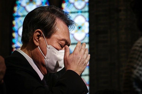 윤석열 대통령이 6일 서울 중구 명동성당에서 열린 이태원 참사 희생자 추모 미사에서 성호를 긋고 있다. 
