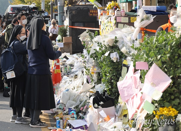 7일 오전 서울 용산구 이태원역 1번 출구에 조성된 이태원 압사 참사 추모공간에서 수녀들이 희생자들의 안타까운 죽음을 애도하고 있다.