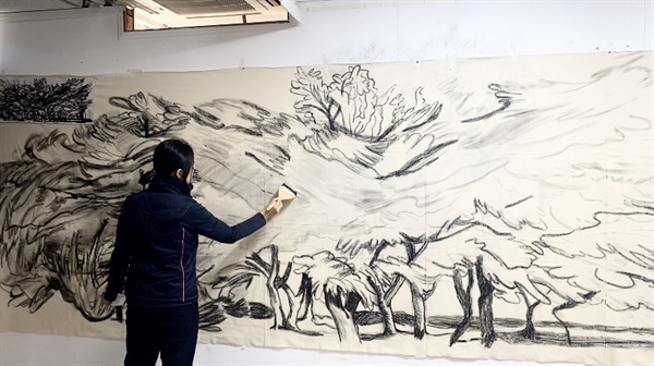 김세연 작가가 최근 어느 갤러리 벽면에 구름풍경을  라이브 드로잉으로 그리고 있다.