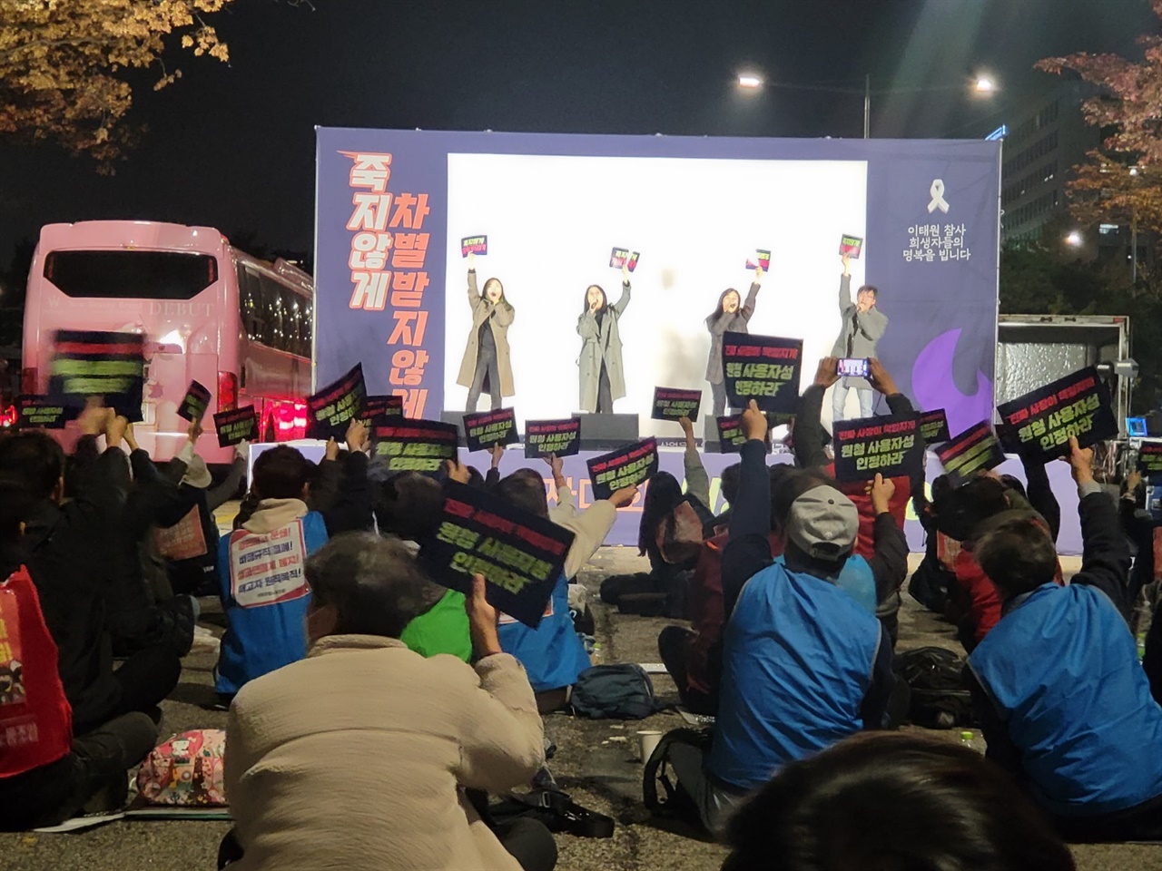 11일 오후 서울 영등포구 산업은행 본점 앞에서 열린 전국노동자대회 비정규직 전야제에서 참가자들이 노래공연에 맟줘 손팻말을 들며 함께하고 있다. 