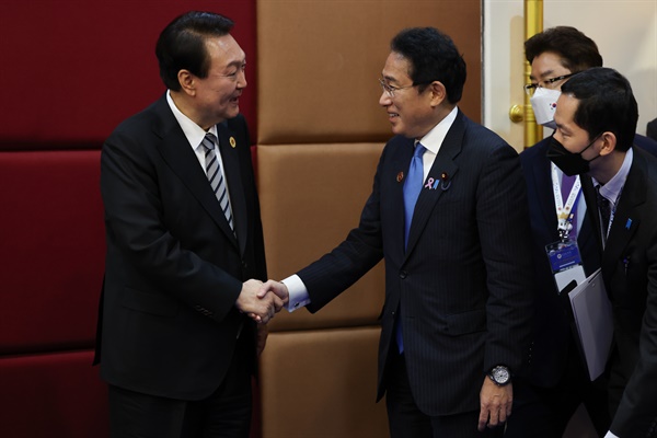 윤석열 대통령이 2022년 11월 13일(현지시간) 캄보디아 프놈펜의 한 호텔에서 열린 한일 정상회담에서 기시다 후미오 일본 총리와 악수하고 있다.