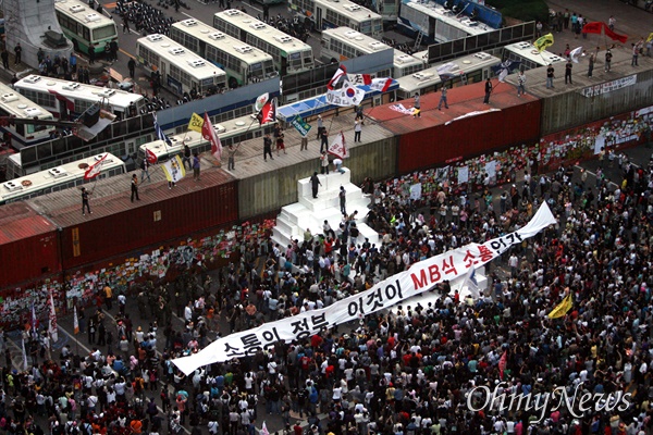  미국산쇠고기 수입 전면 재협상 촉구 및 국민무시 이명박 정권 심판 100만 촛불대행진에 참석했던 시민, 학생들이 11일 새벽 서울 세종로네거리에서 컨테이너 바리케이트 설치를 비난하며 '소통의 정부, 이것이 MB식 소통인가' 글이 적힌 현수막을 펼치고 있다.