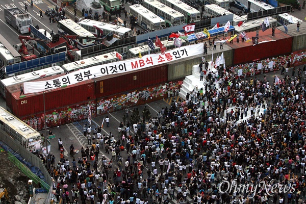 미국산쇠고기 수입 전면 재협상 촉구 및 국민무시 이명박 정권 심판 100만 촛불대행진에 참석했던 시민, 학생들이 11일 새벽 서울 세종로네거리에서 컨테이너 바리케이트 설치를 비난하며 '소통의 정부, 이것이 MB식 소통인가' 글이 적힌 현수막을 펼치고 있다.