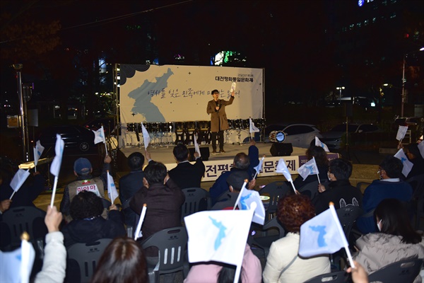 제5회 대전평화통일문화제가 11월 21일(월) 저녁 7시에 대전 평화의소녀상 앞에서 진행되었다. 사회를 맡은 대전청년회 김원진 대표가 구호를 외치고 있다.
