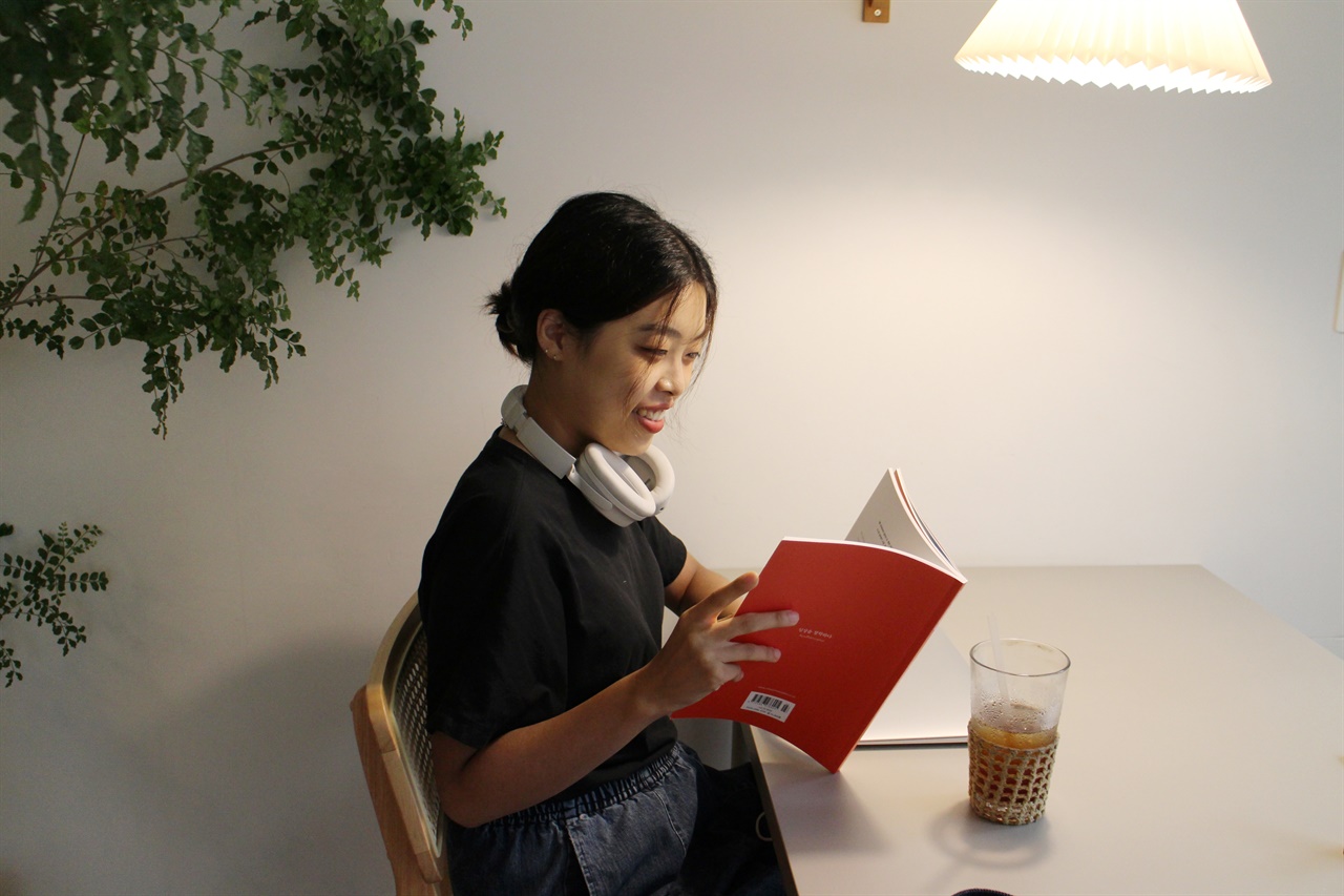 김은미씨가 평소 좋아하는 수원의 한 카페에서 책을 읽으며 웃고 있다. 그는 같은 PM 직무를 준비하던 취업 준비생들과 함께하는 독서 모임을 도맡아 이끌 정도로 열정적이다. 