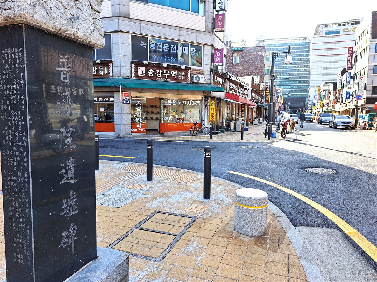 서울 약령시에 안에 위치한 '서울 한방 진흥센터' 앞에 서 있는 '보제원 유허비'와 주변 거리 모습.