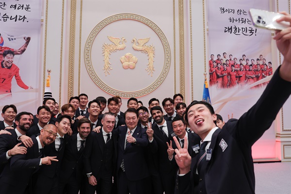 윤석열 대통령이 8일 청와대 영빈관에서 열린 축구 국가대표팀 환영 만찬을 마친 뒤 대표선수들과 함께 기념촬영을 하고 있다.  