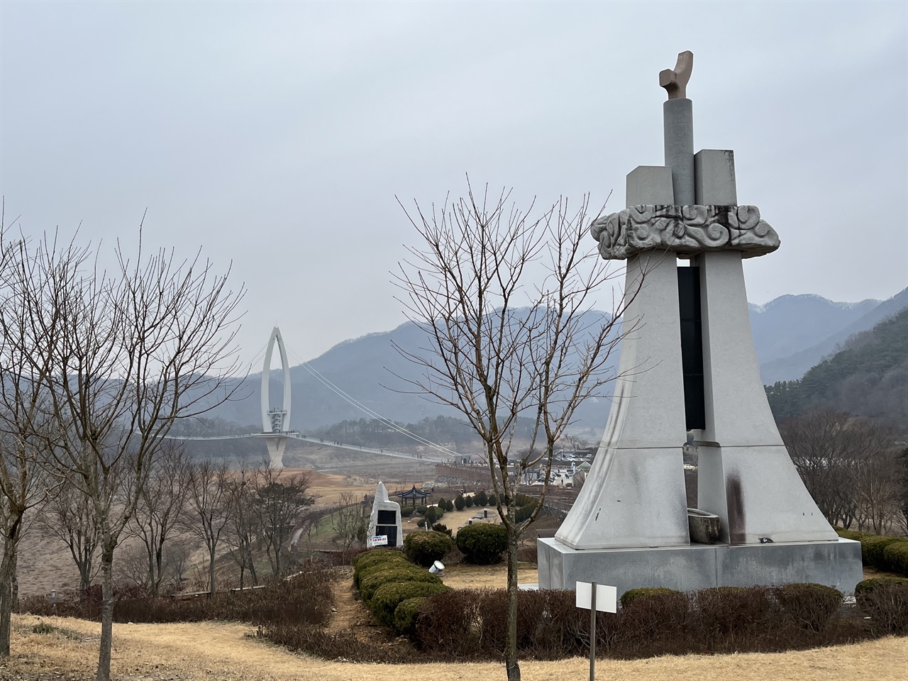  옥정호에 안긴 붕어섬 출렁다리와 요산공원의 망향탑이 아침 안개를 배경으로 조화로운 풍경이 되고 있다.