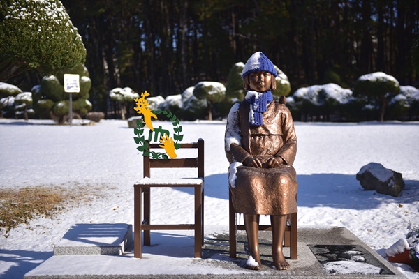 충남대학교 평화의 소녀상에는 충남대학교 로고를 배경으로 손을 맞잡으려는 형상이 의자 위에 붙어 있다.