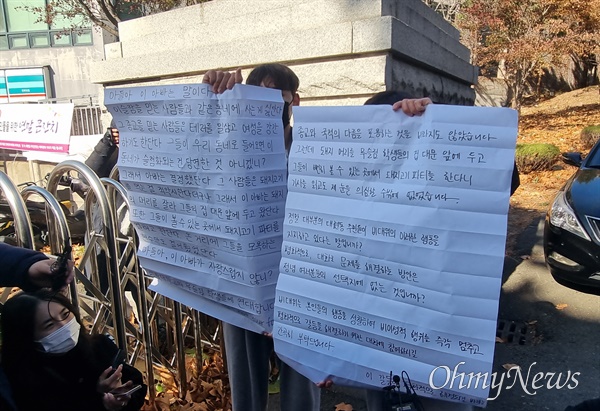 이슬람사원 건축을 반대하는 주민들이 15일 경북대 앞에서 기자회견을 열고 돼지고기 바비큐 파티를 예고하자 경북대 학생들이 대자보를 붙이고자 했지만 주민들이 거세게 항의하자 펼쳐서 들어보이고 있다.