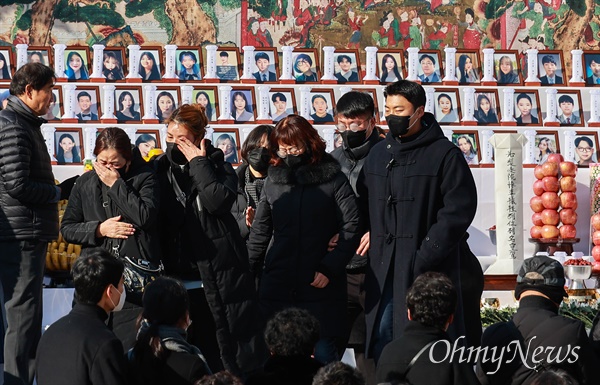  헌화를 마친 유가족들이 눈물을 흘리며 자리로 돌아가고 있다.