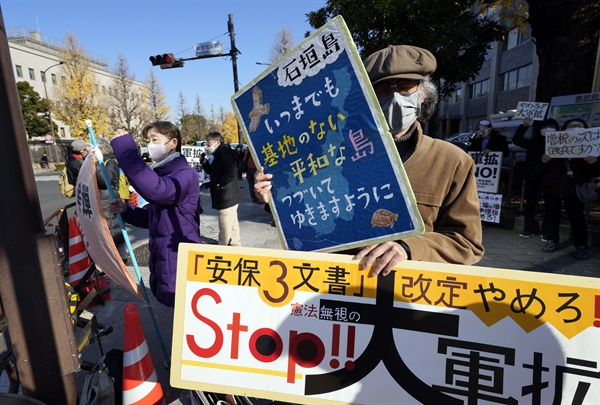 일본 시민들이 16일 도쿄 총리 관저 근처에서 군사력 확대 반대 시위를 벌이고 있다. 일본 정부는 이날 열린 임시 각의(閣議·국무회의)에서 반격 능력 보유를 포함해 방위력을 근본적으로 강화하는 내용이 담긴 3대 안보 문서 개정을 결정했다.