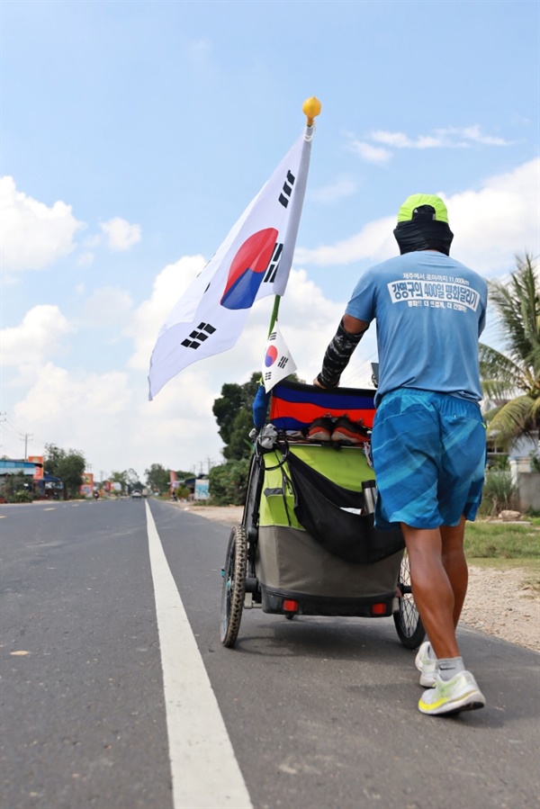 펄럭이는 태극기를 매단 채 1만1천km 평화 달리기에 나선 강명구 평화 마라토너의 뒷모습. 그의 다음 방문 국가는 태국이다.