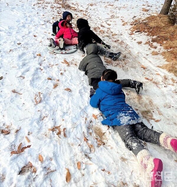 아이들이 눈밭을 구르며 즐거운 시간을 보내고 있다.