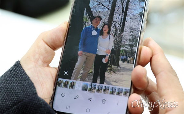 이태원 참사 희생자인 이주영씨 아버지 이정민씨가 가족 여행에서 딸과 함께 찍은 사진을 보여주며 지난날을 회상하고 있다.