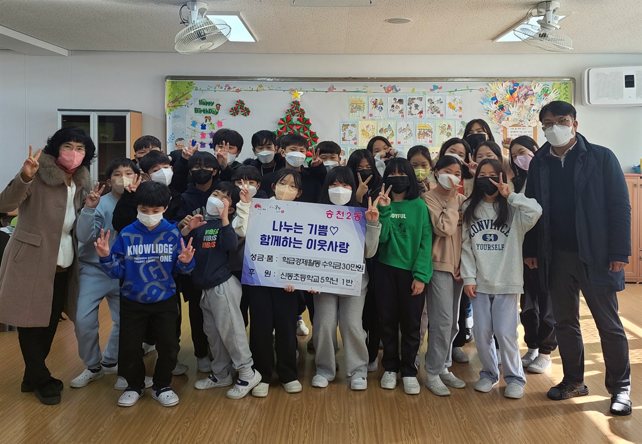 송천2동 주민자치센터에 기부를 하고, 포즈를 취하고 있는 신동초등학교 5학년 1반 학생들 모습.