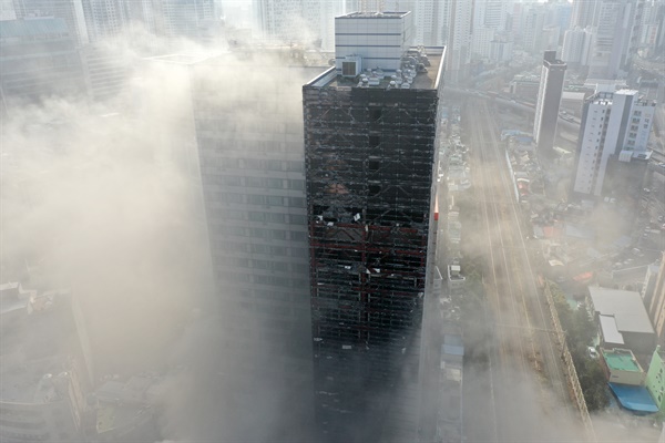 1월 9일 오전 부산진구 한 오피스텔 주차타워에서 불이나 인근 상가로 번져 소방대원이 화재를 진압하고 있다.