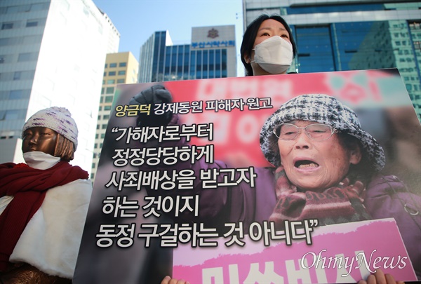  지난 1월 11일 부산 일본영사관 앞에서 부산 시민사회단체의 규탄 기자회견이 열리고 있다. 피해자인 양금덕 할머니의 사진과 발언을 담은 피켓을 들고 있는 참가자.