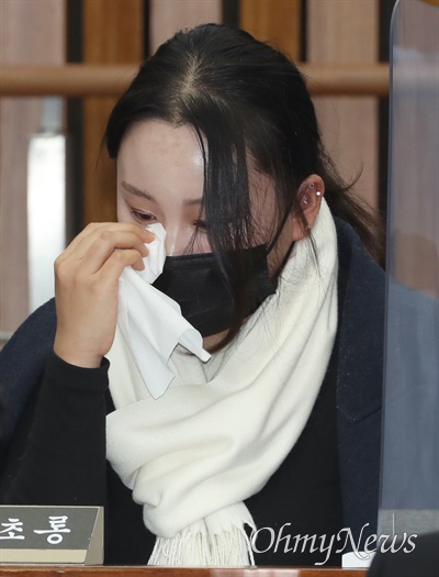 이태원 참사 생존자 김초롱씨가 지난해 1월 12일 서울 여의도 국회에서 열린 이태원 참사 국정조사 2차 공청회에서 진술 도중 눈물을 훔치고 있다.
