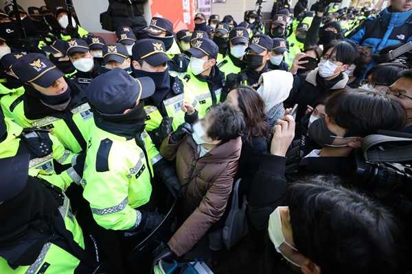 18일 오전 국정원 압수수색이 이루어지고 있는 서울 중구 전국민주노동조합총연맹(민주노총) 서울 사무실 앞에서 민주노총 관계자들이 진입을 시도하며 경찰에 항의하고 있다.