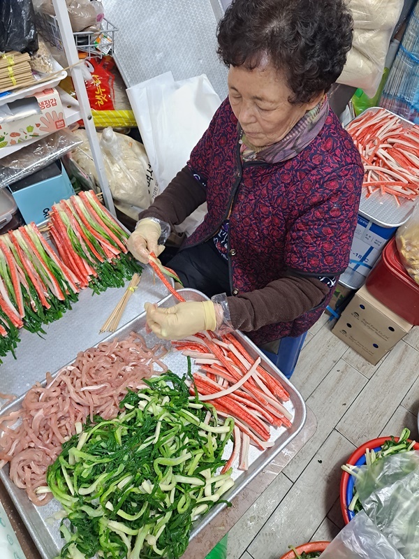 친정어머니가 산적을 꼬지에 꿰고 있다.