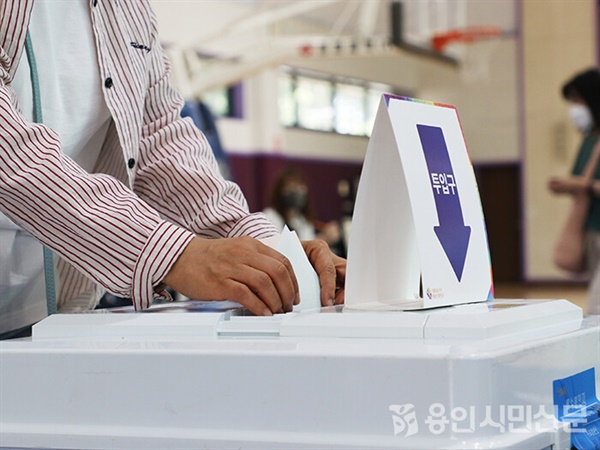 기흥구 신갈초등학교에 설치된 제1투표소 한 유권자가 용지를 투표함에 담고 있다.