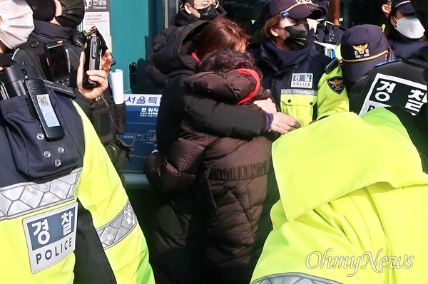 이태원 참사 희생자 유족들이 6일 오전 서울시청 진입을 시도하자 이를 경찰이 제지했다. 시청에 들어가지 못한 유족들이 껴안은 채 눈물을 흘리고 있다.