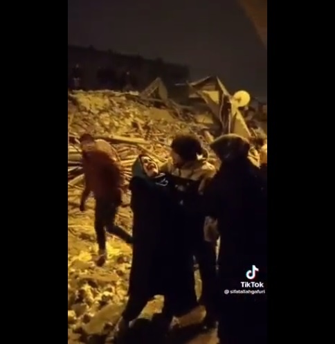 가족들이 갇힌 건물 잔해 앞에서 울부 짖는 한 여성 