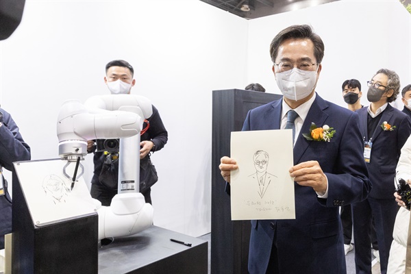김동연 경기도지사가 2022 디지털미디어테크쇼가 열리고 있는 23일 오전 고양시 일산서구 킨텍스 1전시장에서 드로잉 로봇이 그린 초상화를 들고 있다.