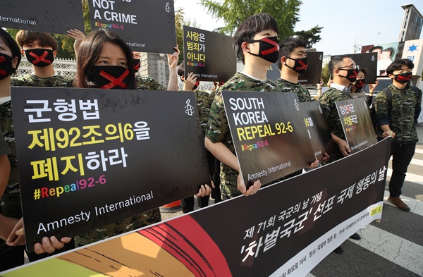 2019년 10월 1일 국제앰네스티 한국지부 관계자들이 제71회 국군의 날에 서울 용산구 국방부 앞에서 '차별국군' 선포 국제 행동의 날 기자회견을 하며 침묵 속에 복무 중인 군인들을 상징하는 X자 표시가 된 마스크를 쓰고 있다. 이들은 군형법 제92조의6이 성소수자 군인을 처벌의 위협으로 내몰고 있다며 이 조항의 폐지를 촉구했다. 