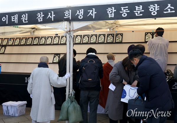 14일 오후 서울 용산구 이태원광장에 마련된 10.29 이태원 참사 희생자 분향소를 이전하자, 종교인들이 참석하지 못한 유가족을 대신해 영정사진을 모시고 있다.