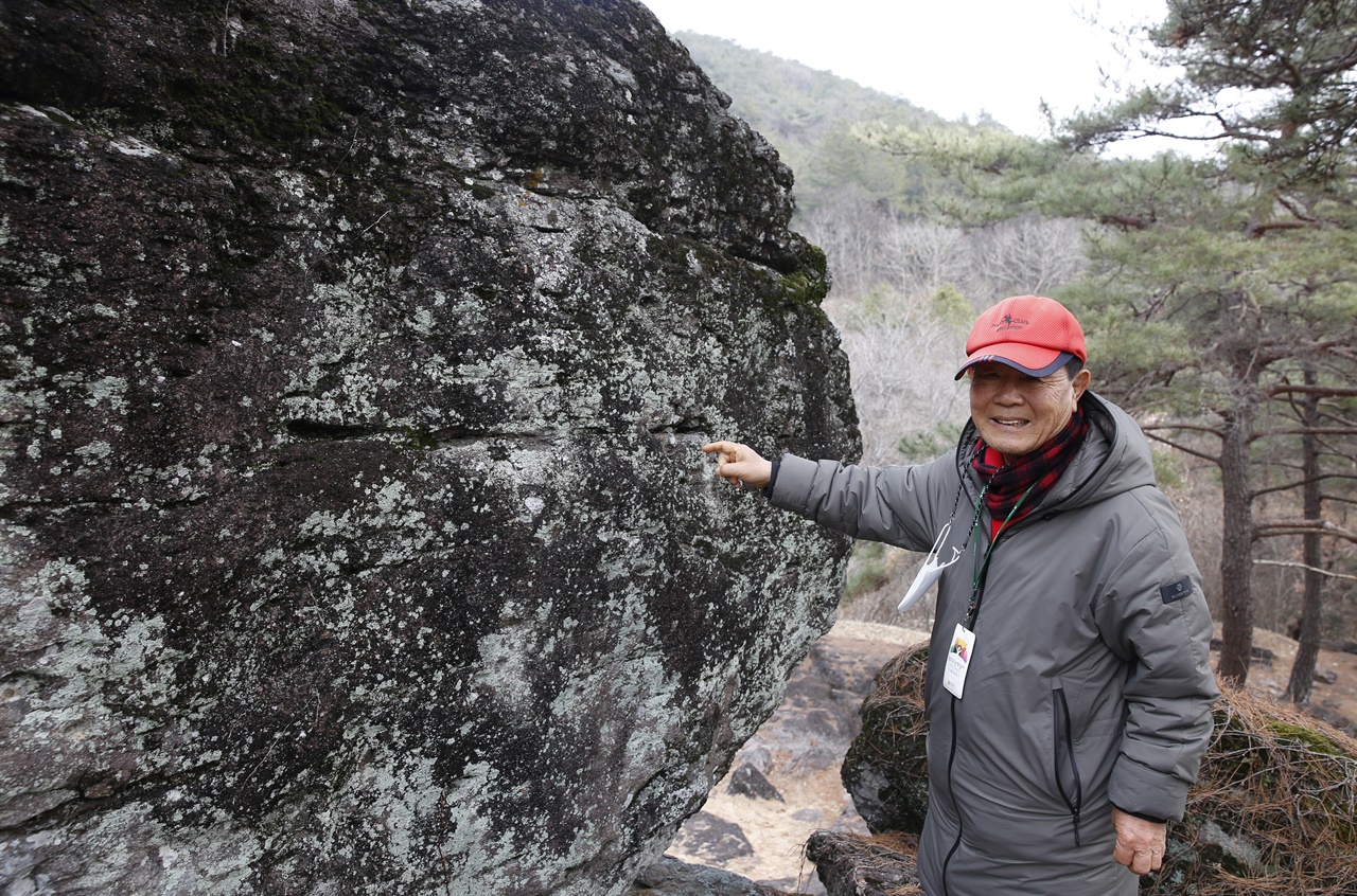 최종채 화순문화관광해설가가 감태바위에서 덮개돌을 떼어내려고 한 흔적을 가리키고 있다.