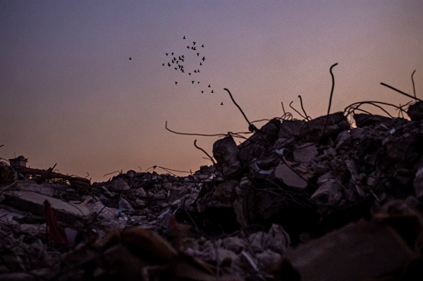 지난 16일 튀르키예 하타이에서 강력한 지진 후 무너진 건물 잔해 위로 새들이 날아가고 있다.