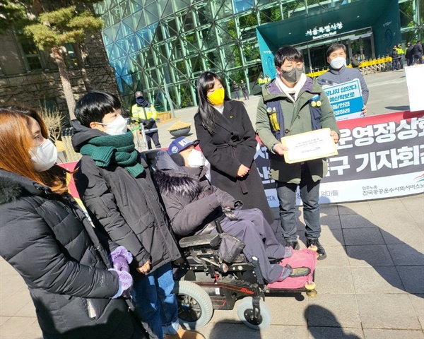 서울시에 이용자, 보호자 서명명단을 제출하는 기자회견 참가자들(공공운수노조 제공)