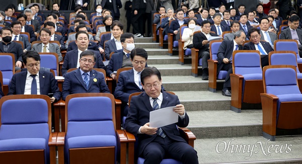 이재명 더불어민주당 대표가 2월 21일 오후 서울 여의도 국회에서 열린 의원총회에 참석해 당 전략위에서 여론조사를 분석한 자료를 보고 있다.