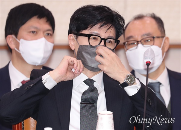 한동훈 법무부 장관이 지난 23일 서울 여의도 국회에서 열린 법제사법위원회 전체회의에 출석해 마스크를 고쳐쓰고 있다.
