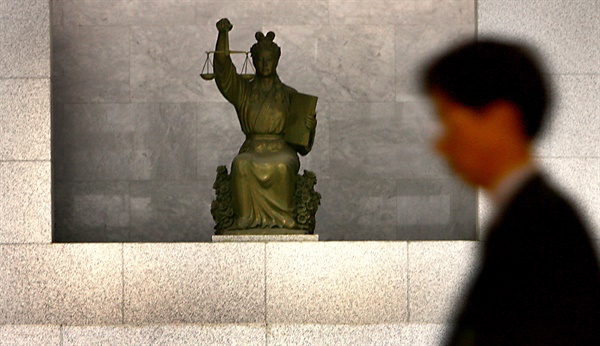 대법원 직원이 정의의 여신상 앞을 지나가고 있다. 