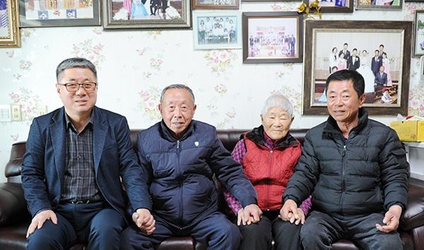 ???????김칠봉·권영예 어르신이 장남 인배(오른쪽)씨, 차남 창배(왼쪽)씨와 손을 잡고 사진을 찍고 있다. 