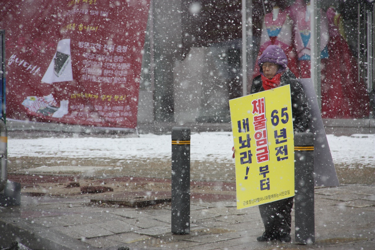 2010년 3월, 눈보라가 몰아치는 속에서 양금덕 할머니가 미쓰비시자동차 광주전시장 앞에서 1인 시위에 나서고 있다. 
