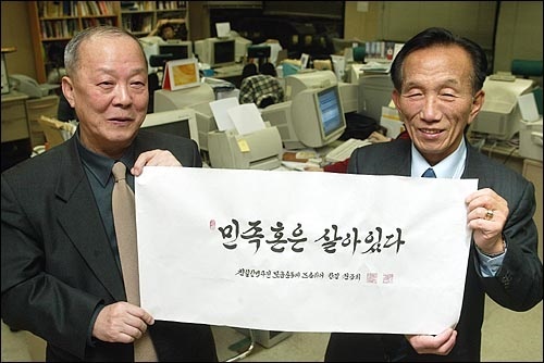 권중희 선생(오른쪽)과 기자가 '민족혼은 살아있다'라는 권중희 선생의 휘호를 펼치고 있다(2004년). 