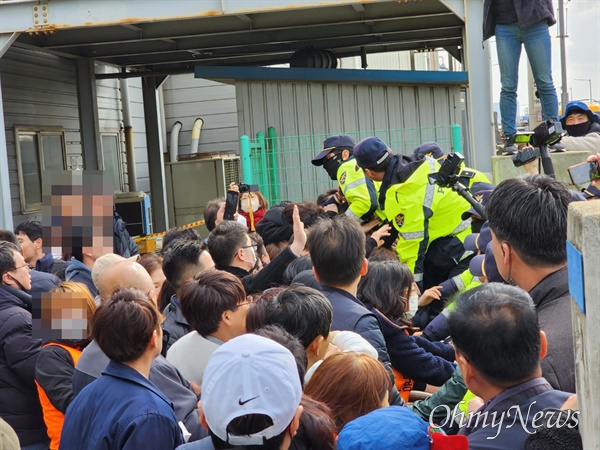 자바라 형태 공장 문을 넘어오는 경찰, 저지하는 노동자들
