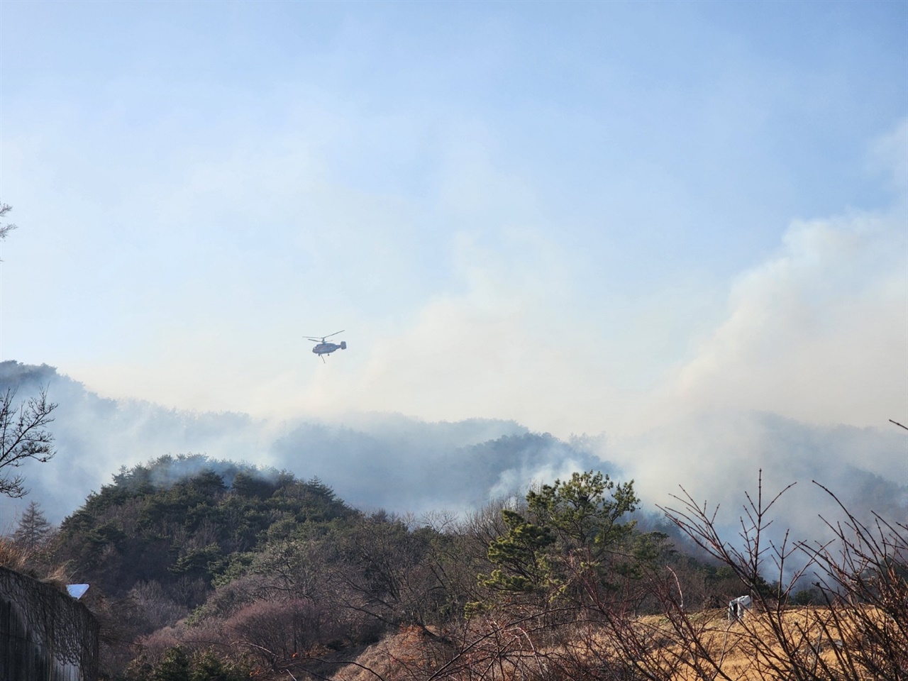 충남 부여군 옥산면 산불 현장에 소방 헬기가 투입되어 화재를 진압하고 있다.