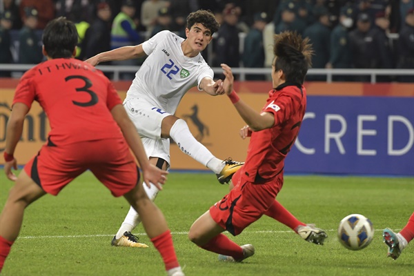  3월 15일 우즈베키스탄 타슈켄트의 분요드코르 스타디움에서 열린 아시아축구연맹 U20 아시안컵 준결승 축구 경기에서 우즈베키스탄의 셰르조드 에사노프(가운데)가 공을 차는 것을 한국의 김지수가 막아내고 있다. 