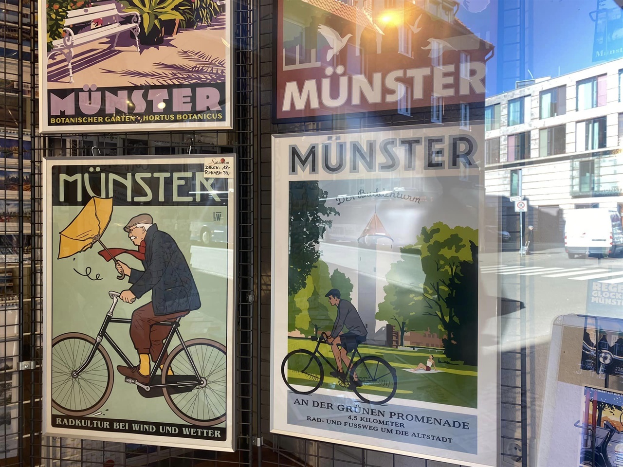 박영운 대표와 정연일 이사가 원정대원이 뮌스터 시청과의 공식일정을 치르고 돌아오는길에 서점에 거려있는 포스터를 찍은 사진이라고 한다. 자전거 도시답게 자전거와 관련한 이야기 거리가 많음이 확인된다.